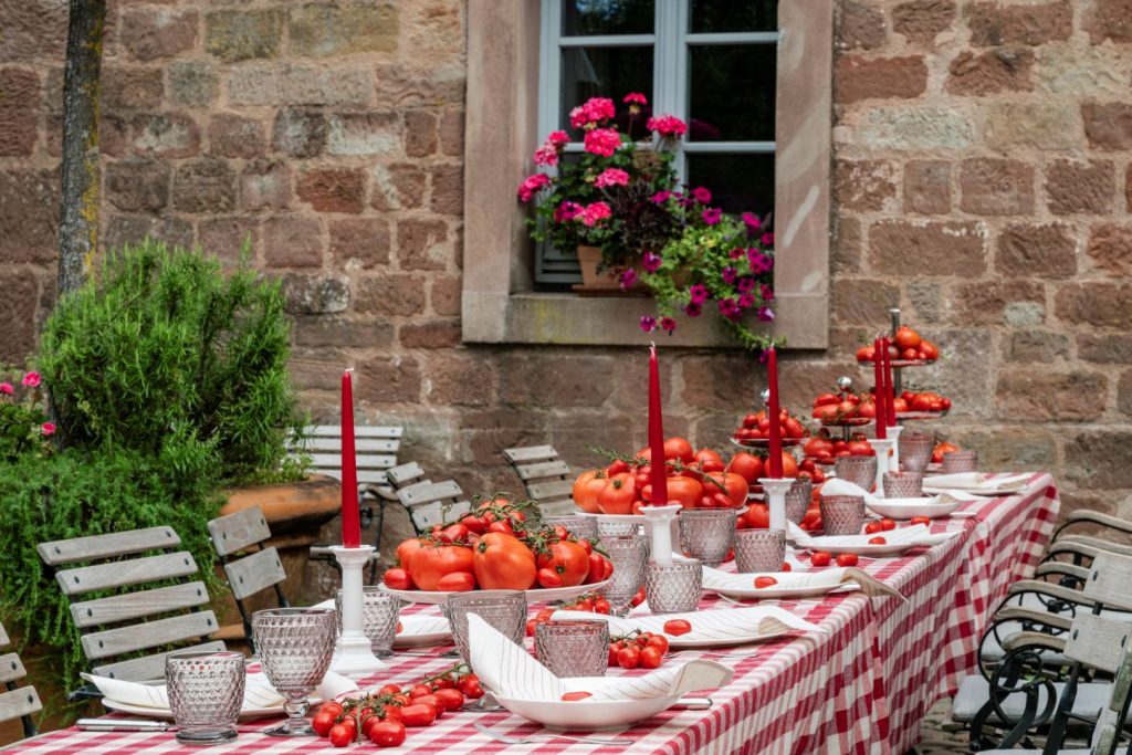 Hochzeitsempfang im Biergarten vor der Klosterschänke des Hotel Kloster Hornbach mit rustikaler Tafel und ungewöhnlicher Tomatendekoration.